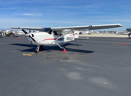 Cessna 172 G1000 N646CB, white with red and blue stripes, on the ramp under a blue sky